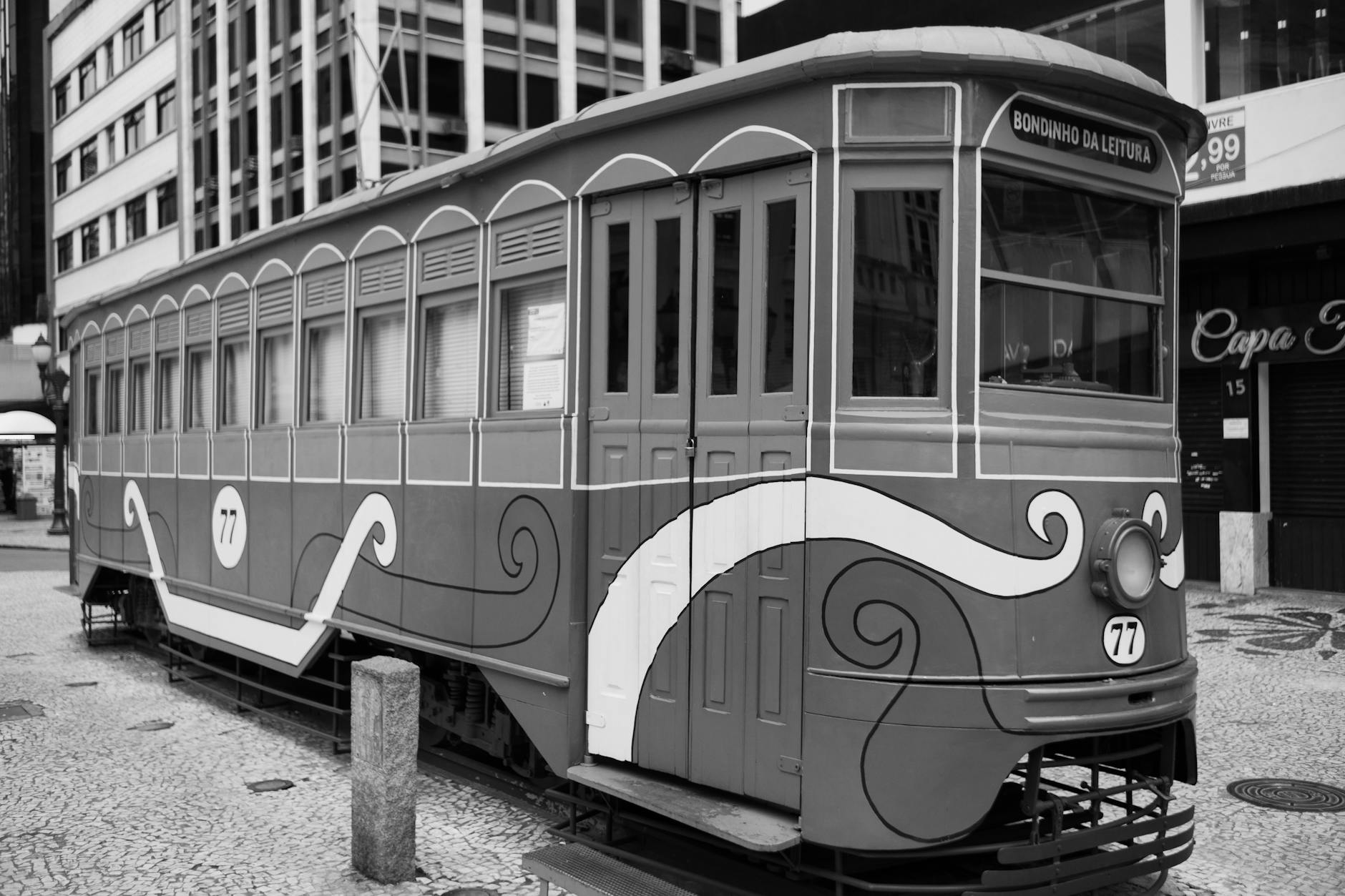 A black and white photo of the iconic Bondinho da Leitura tram in Curitiba, Brazil, highlighting its vintage charm.