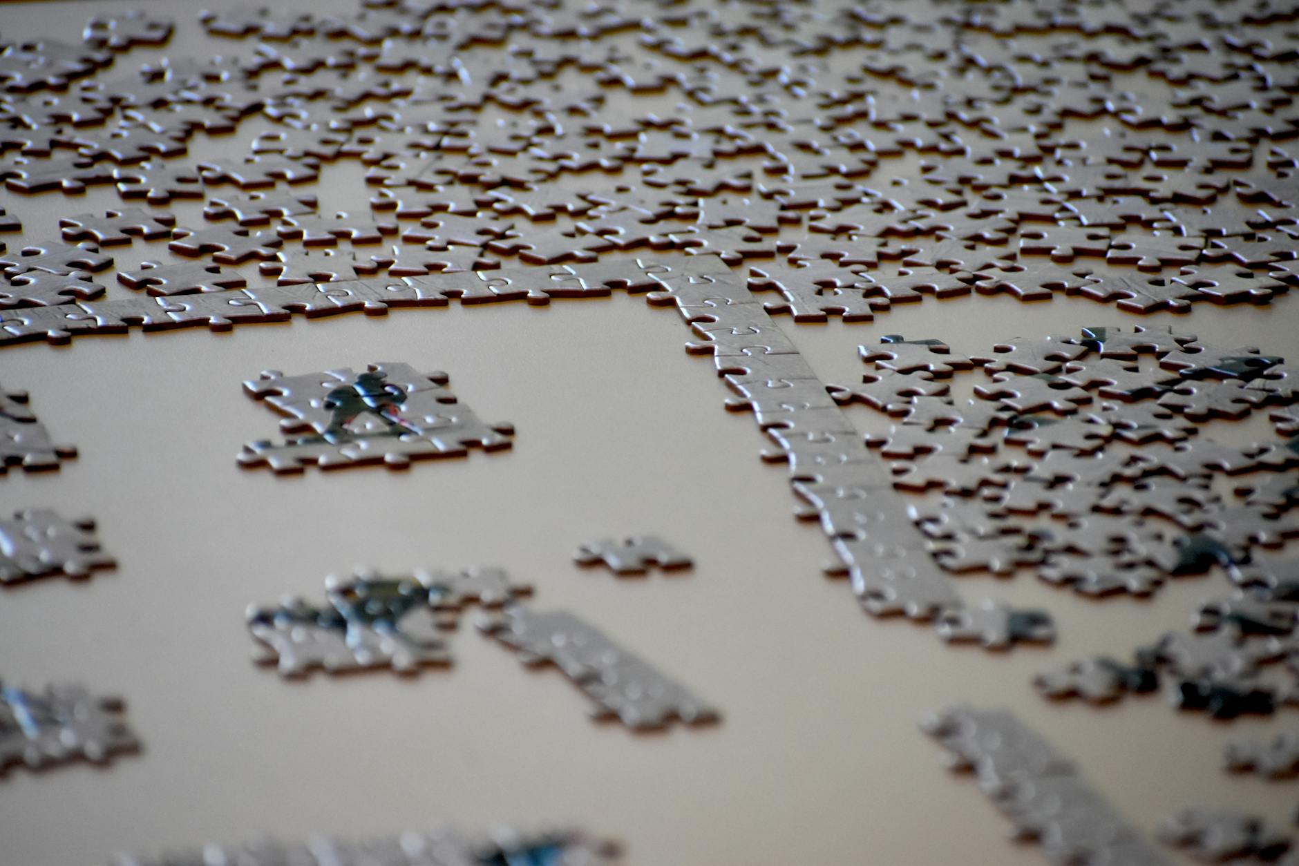 A detailed image of an incomplete jigsaw puzzle with pieces scattered on a table surface.
