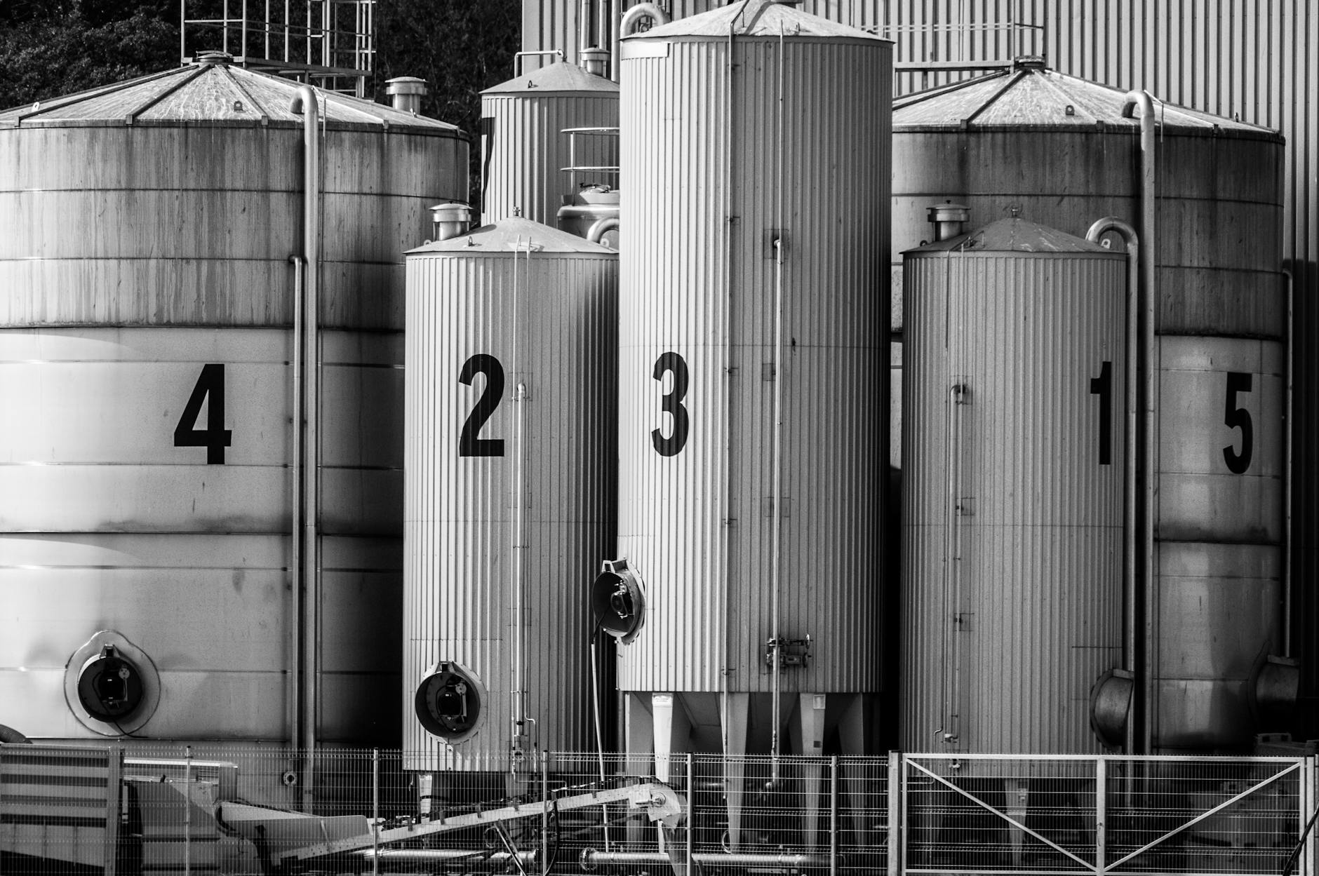 Black and white photo of industrial silos labeled with large numbers 1 to 5.