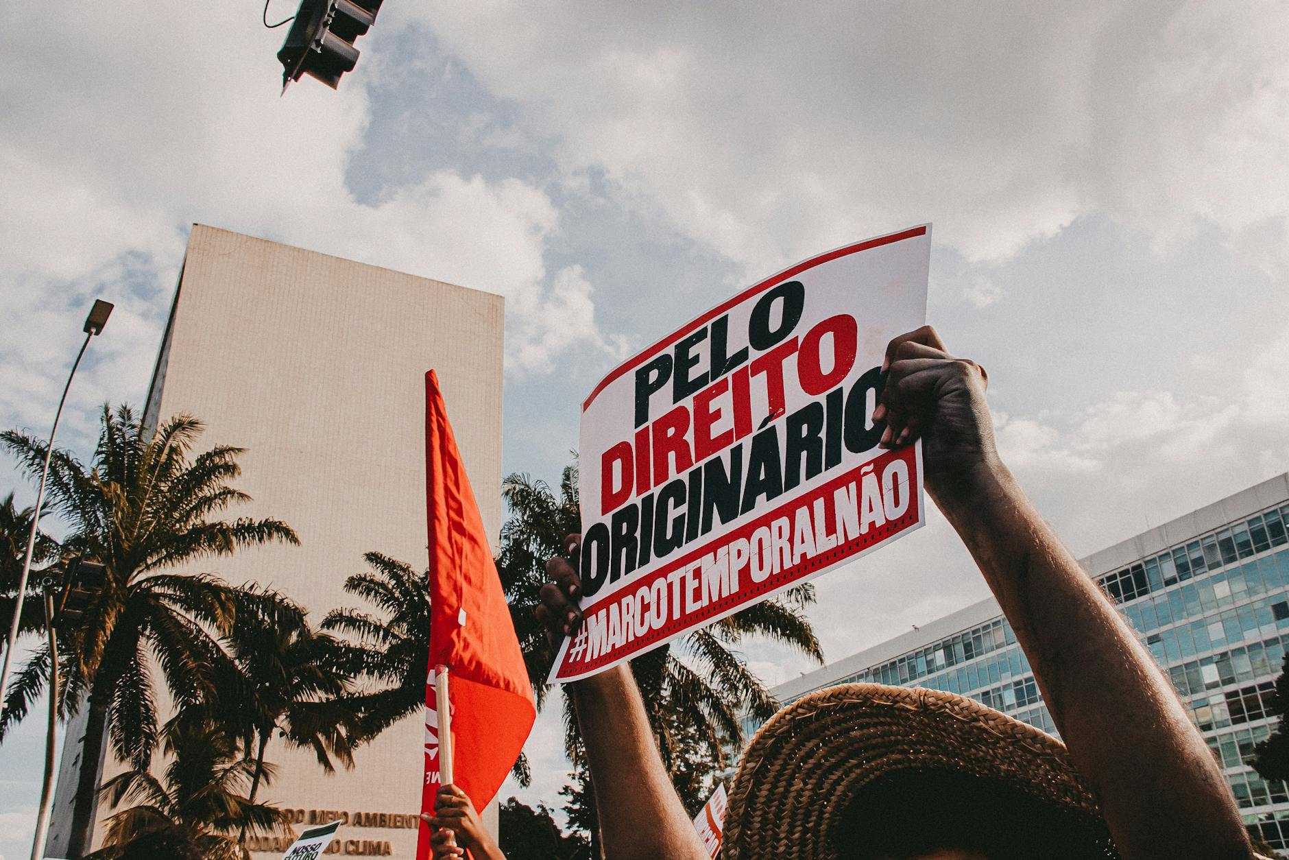 Demonstrators holding signs against Marco Temporal in city protest.