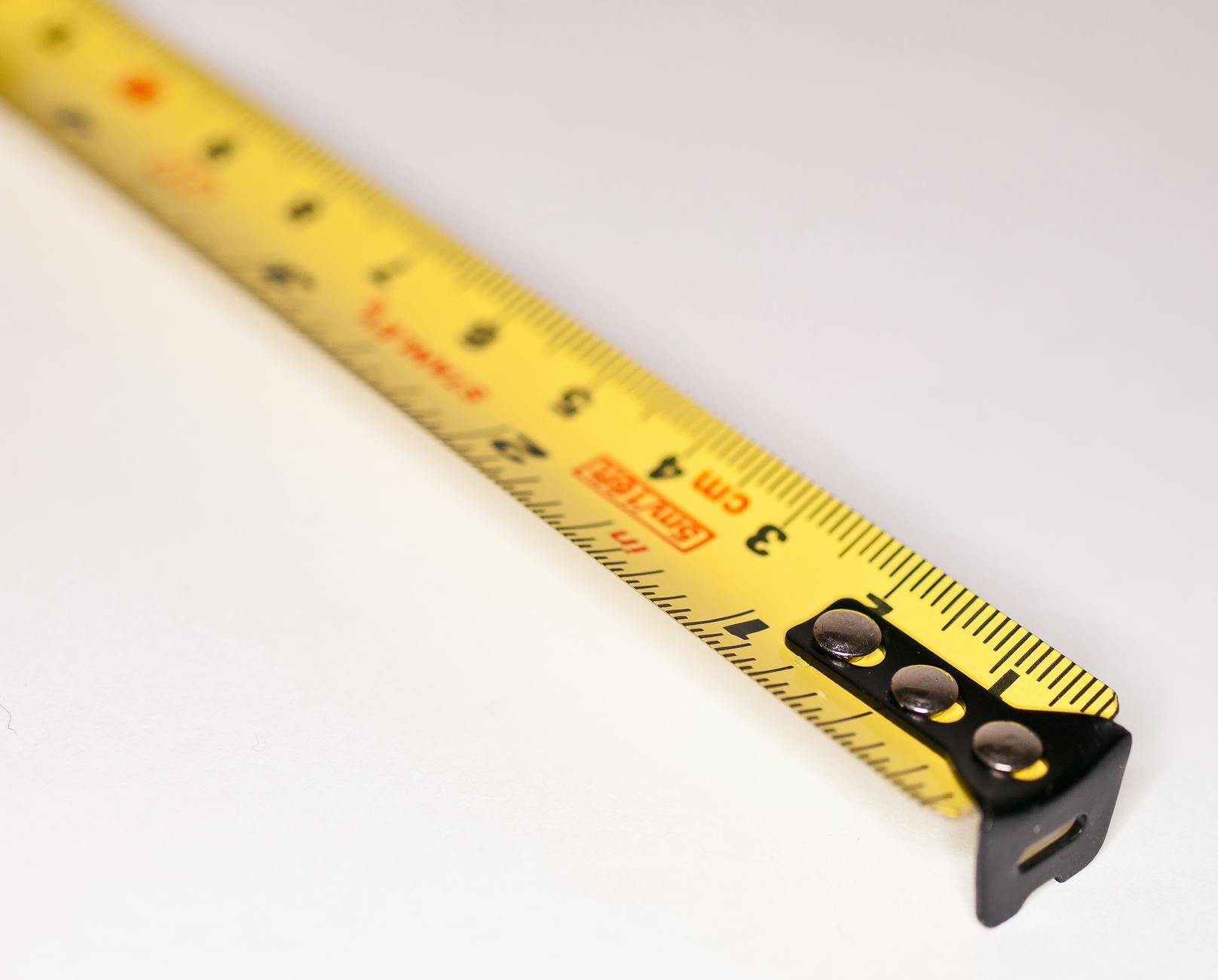 Detailed close-up image of a yellow measuring tape with metric markings.