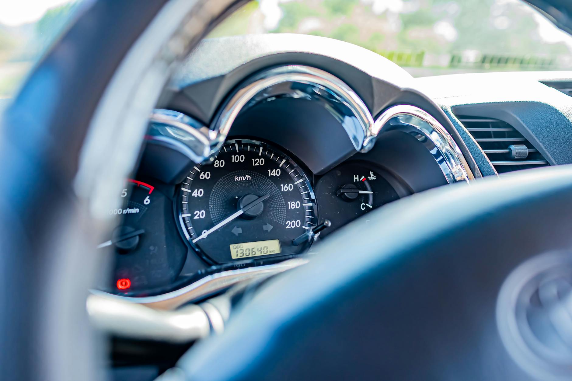 Detailed view of a car's speedometer and gauges from the driver's seat, highlighting instrument clarity.