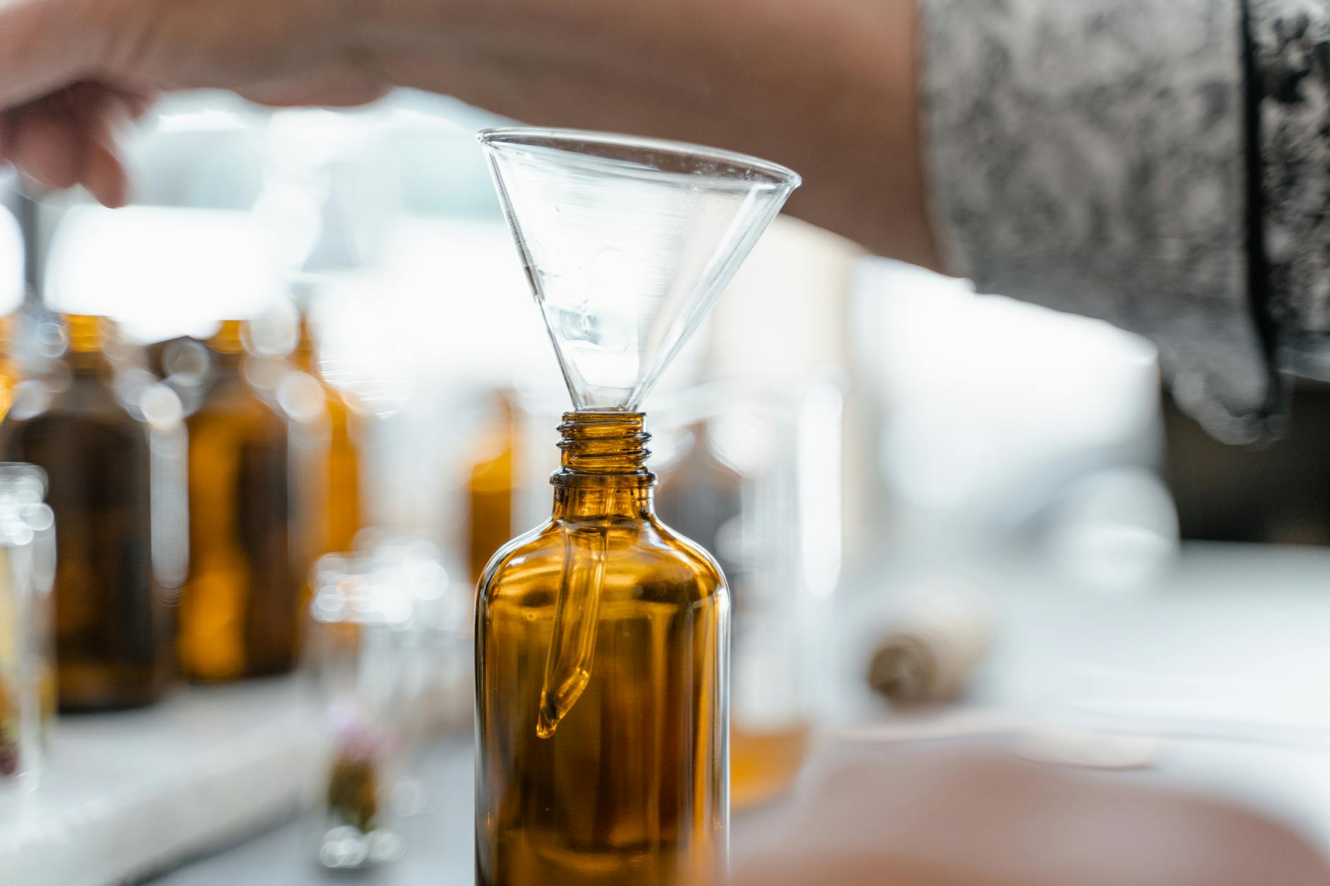 Detailed view of an amber glass bottle with a funnel, perfect for laboratory setups.