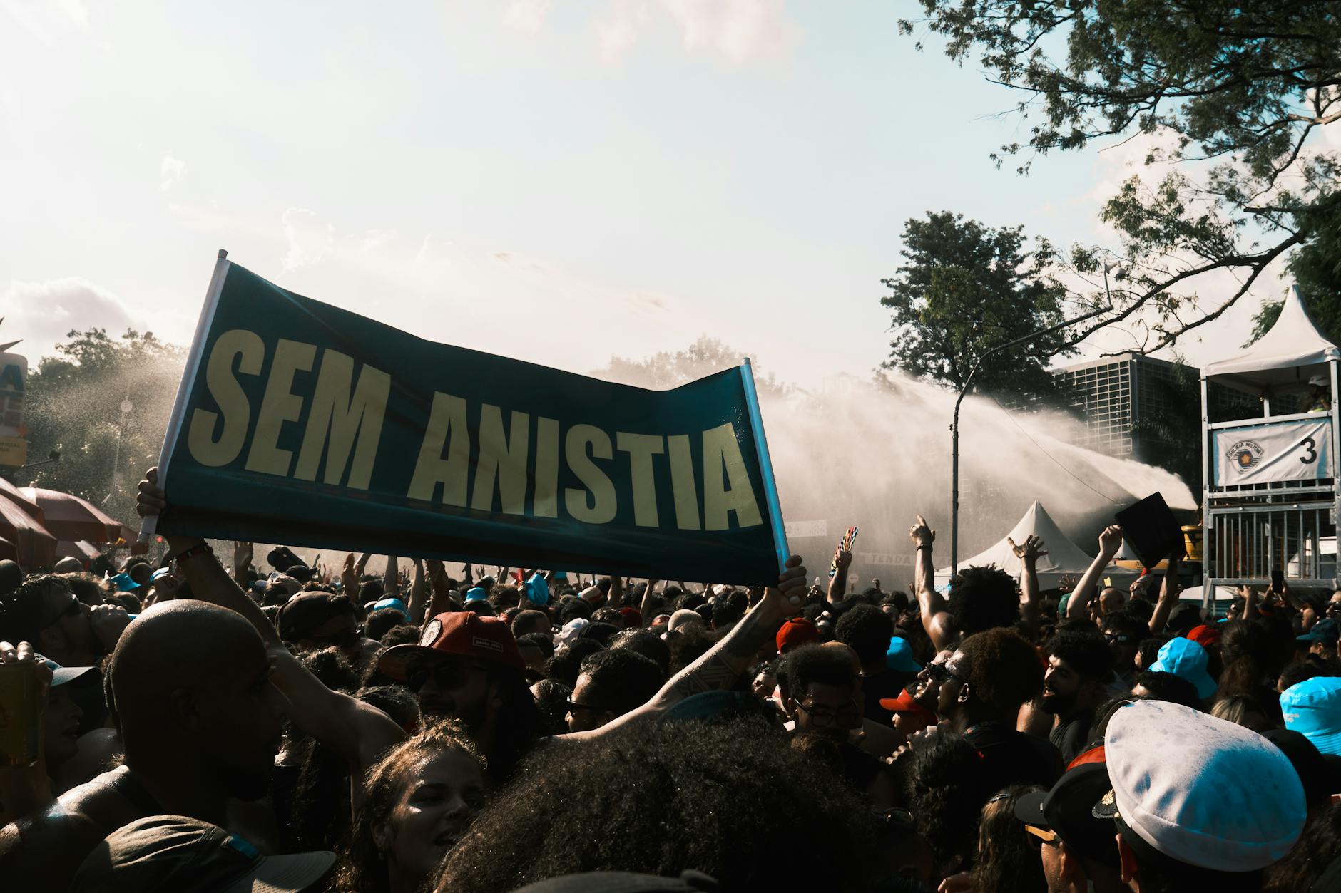 Large crowd demonstrating with a 'Sem Anistia' banner, conveying a powerful protest message.