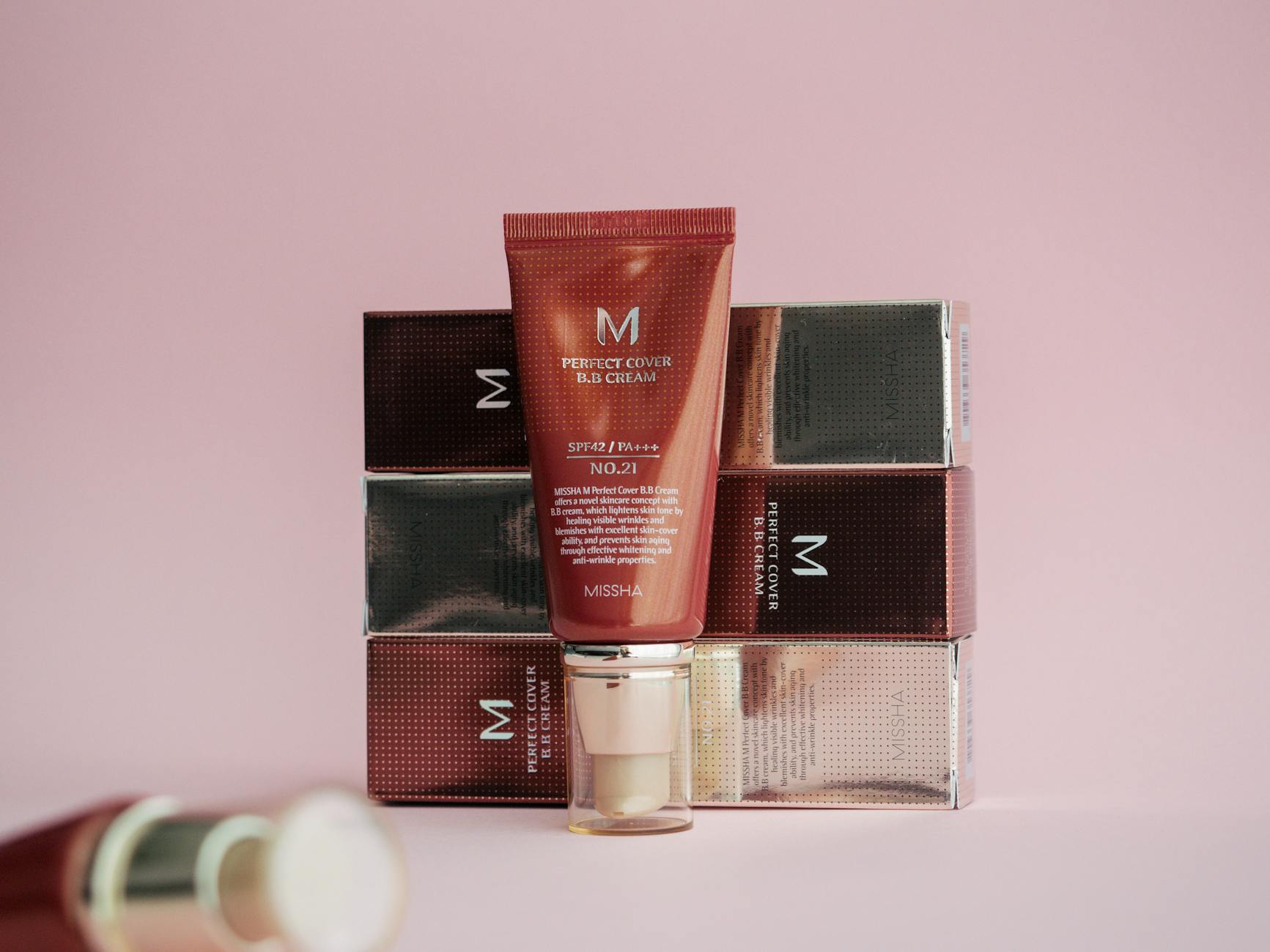 Stylish display of Missha Perfect Cover BB Cream on pink background with packaging.