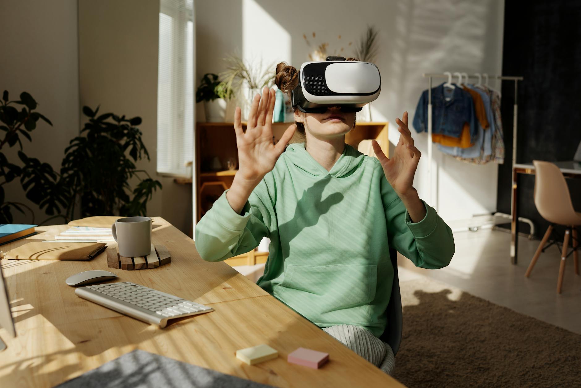Teenage girl experiencing virtual reality at home with a VR headset, surrounded by modern tech.